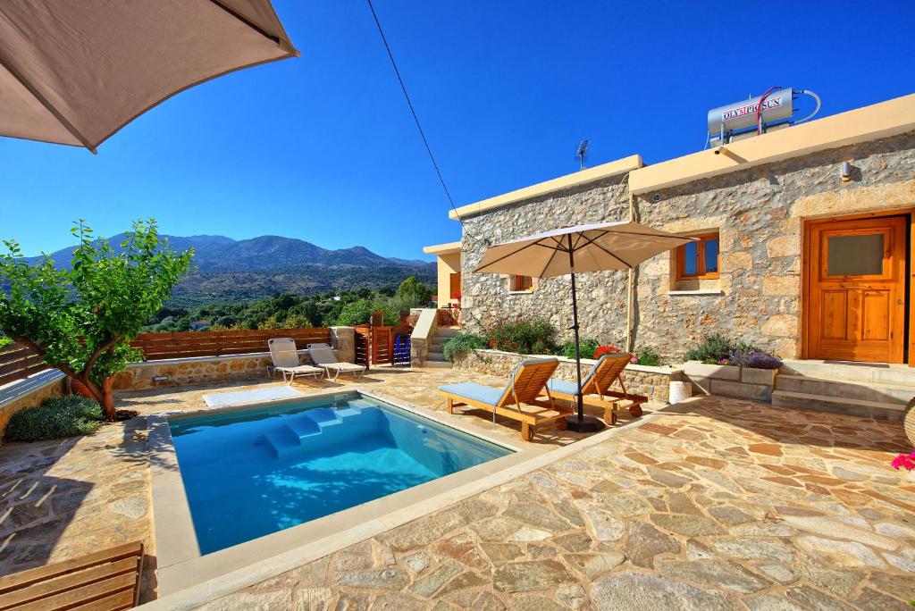 a villa with a swimming pool and a house at Villa Vicilla by PosarelliVillas in Fílippos