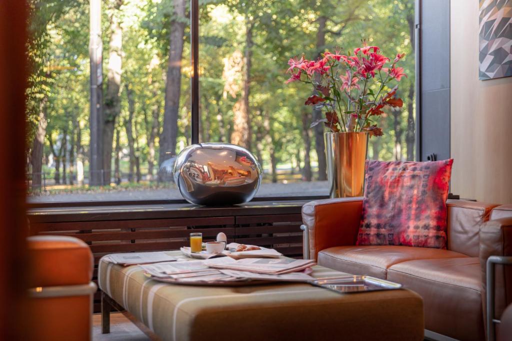 una sala de estar con una mesa y un jarrón de flores en Elite Eden Park Hotel, en Estocolmo