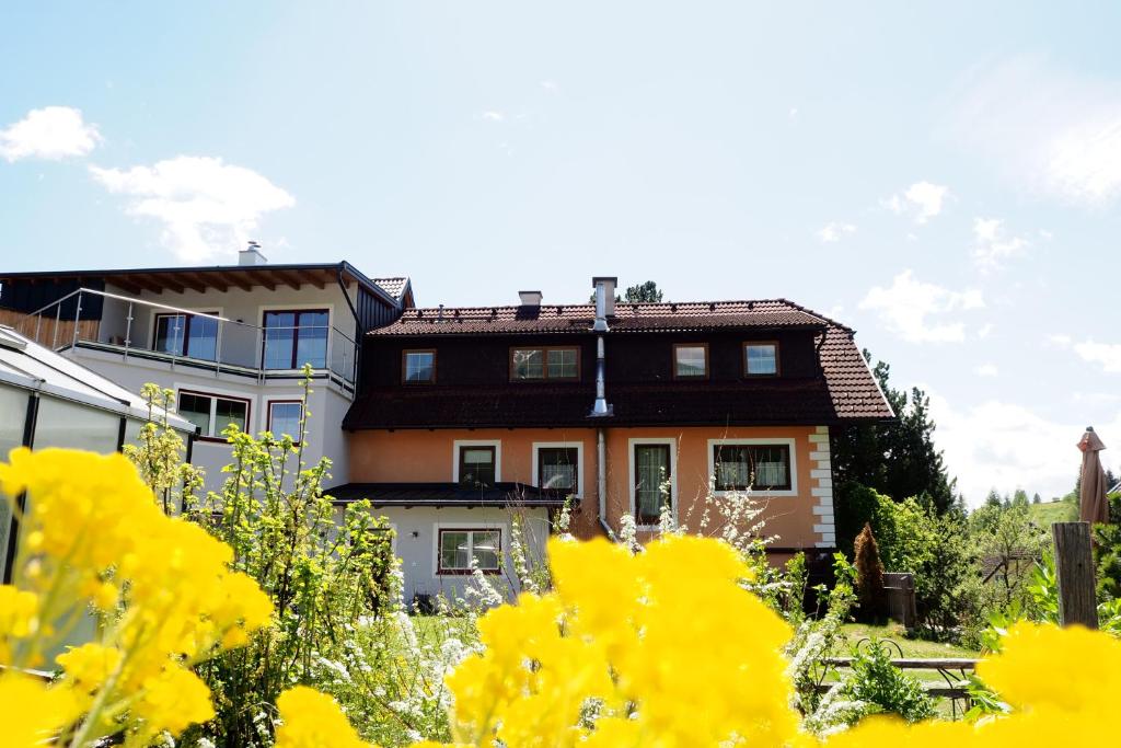 dom z żółtymi kwiatami przed nim w obiekcie Apartment Goaßa - Familie Zehner w mieście Göriach