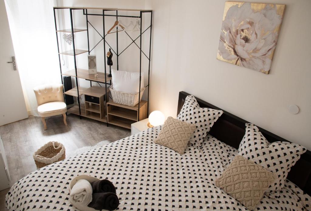 une chambre avec un lit avec des oreillers noirs et blancs dans l'établissement Le COSY Toulouse 3 min de la Gare à pieds Parking gratuit ventilateur, à Toulouse