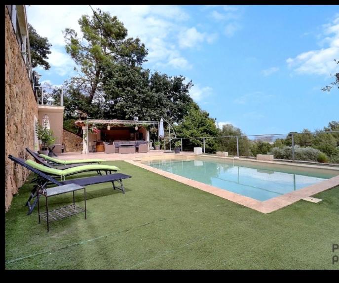 een zwembad met een bank en een tafel bij Charmant logement avec piscine in Le Cannet-des-Maures
