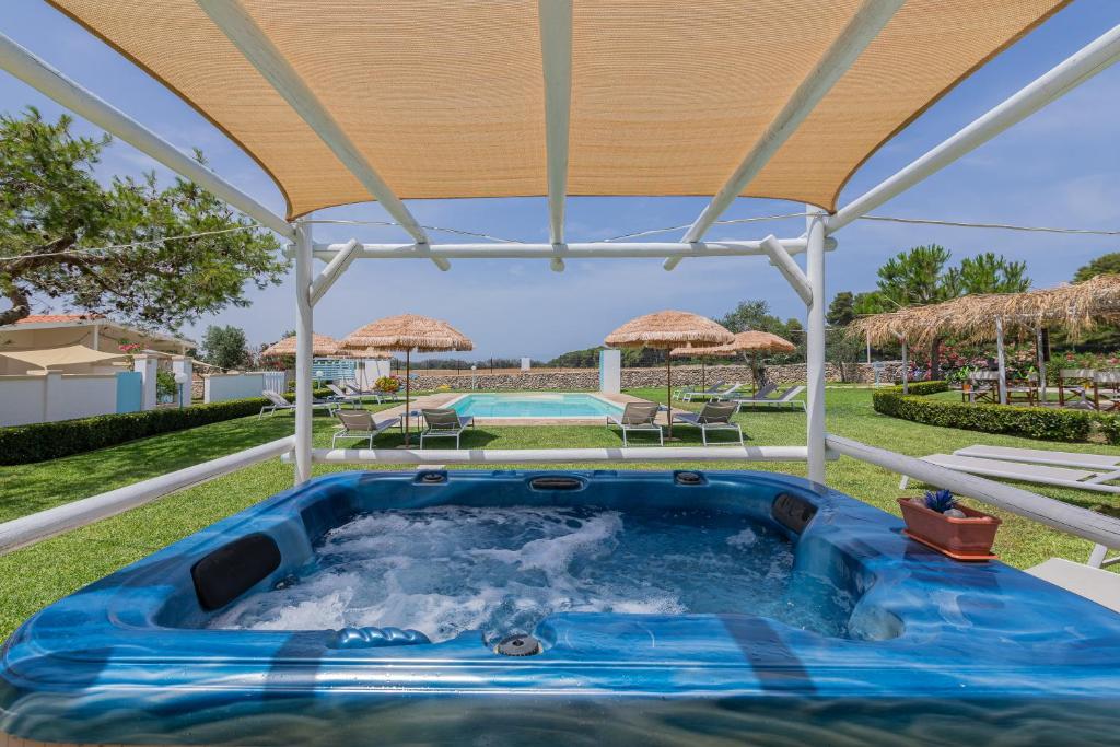 - un bain à remous extérieur sous un pavillon avec un parasol dans l'établissement Case vacanza Gli Oleandri, à Otrante