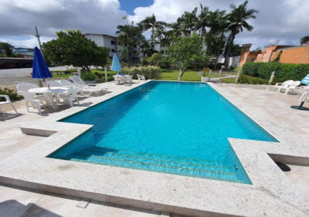 a swimming pool with blue water in a yard at Arco do Sol Park Hotel in Camboriú