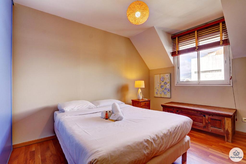 a bedroom with a large white bed with a window at T4 - Le Diva, classé 3 étoiles - 110 m2 - Saint-Denis in Saint-Denis