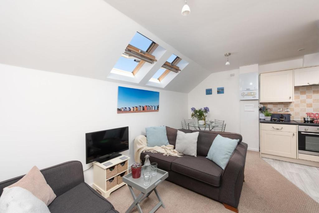 Una sala de estar con un sofá y un televisor. en 7 Trevose House, St Ives, en Carbis Bay