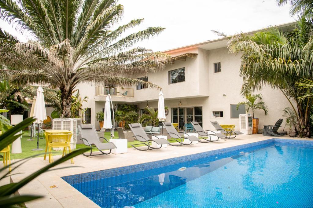 a swimming pool with lounge chairs and a hotel at Le Karé Ébène in Cotonou