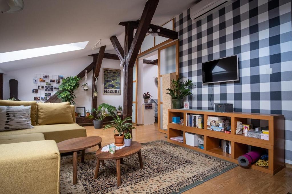 een woonkamer met een bank en een tafel bij Bright Loft Radziwiłłowska Street in Krakau