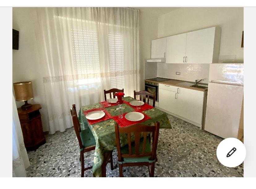 een keuken met een tafel met stoelen en een keuken met een tafel bij Appartamento in centro, a 150 m dal mare in Pineto