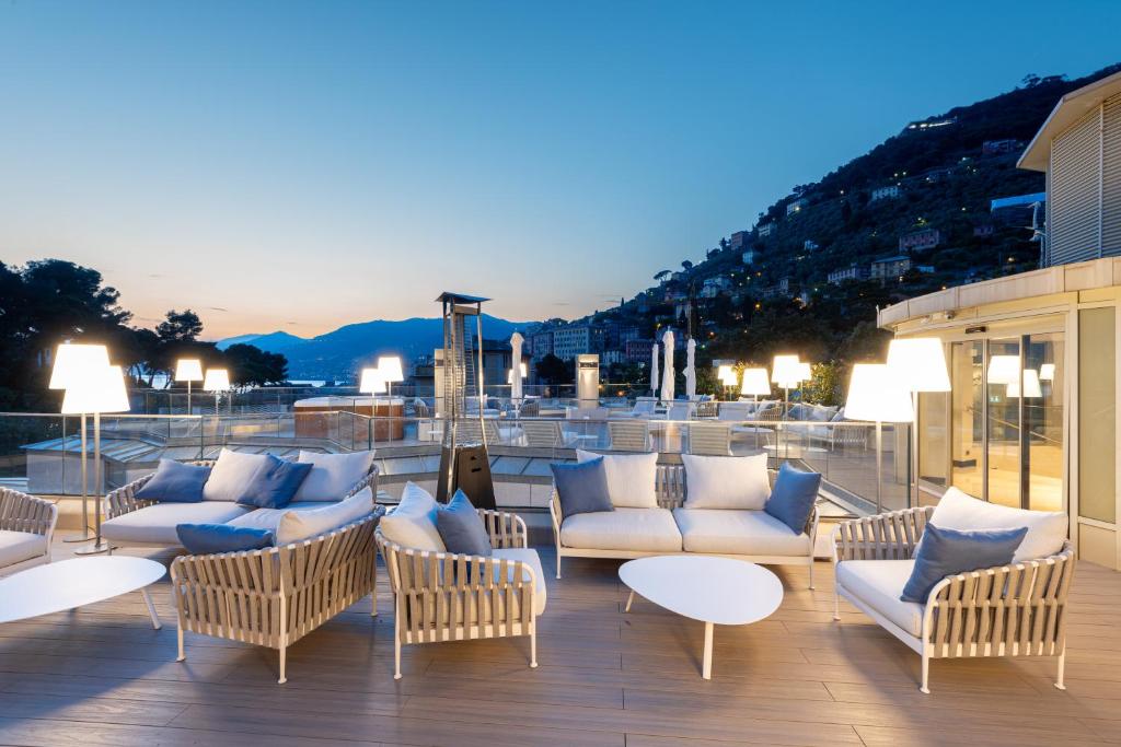 a patio with couches and tables on a deck at Carrick Hotel Camogli Portofino Coast in Camogli