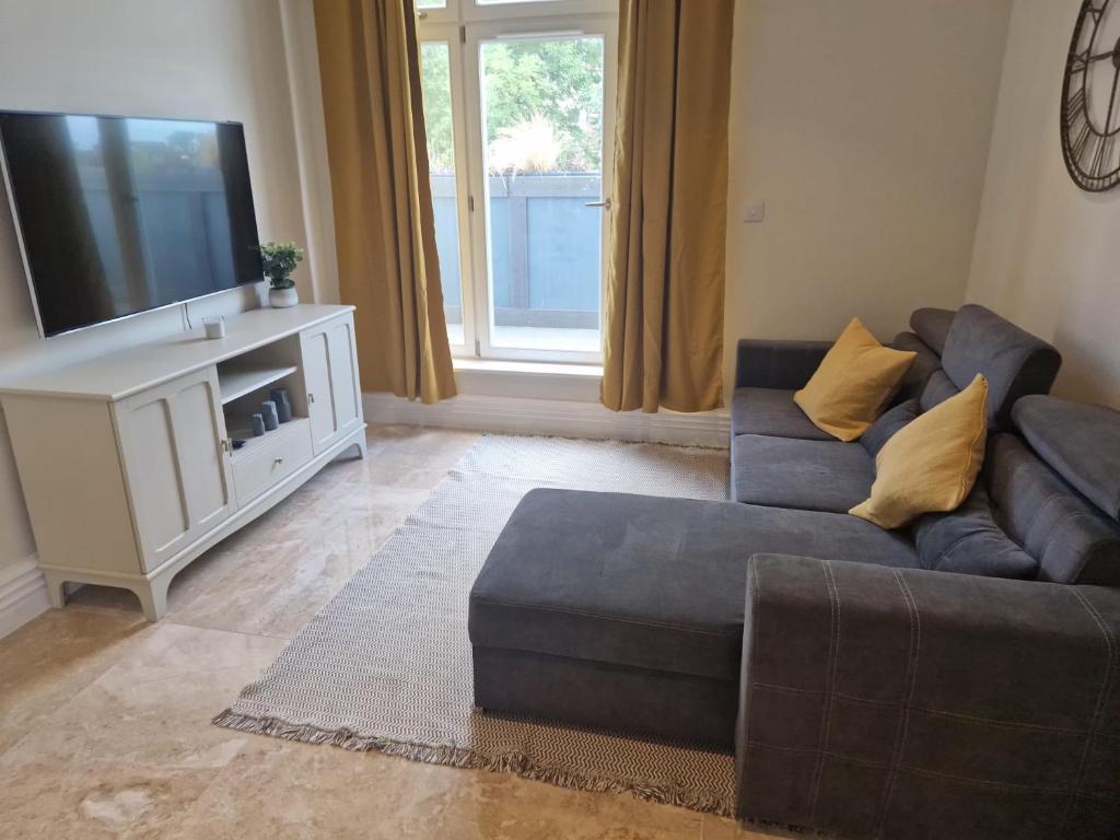 a living room with a couch and a tv at 2 Bedroom Lux Apartment in Hendon- New Build in Colindale