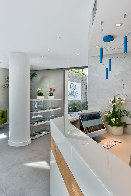 a lobby with a white counter with flowers on it at Carrick Hotel Camogli Portofino Coast in Camogli