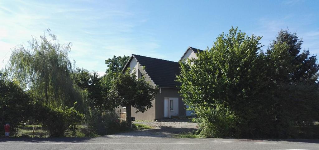 dom z mnóstwem drzew przed nim w obiekcie Vie et Passion w mieście Elsenheim