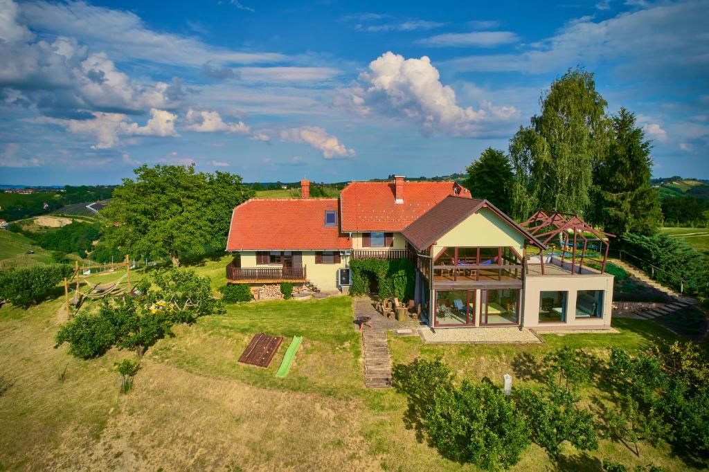 einen Blick über ein Haus mit rotem Dach in der Unterkunft Holiday House Podhamer Marijan private Wellness in Ljutomer