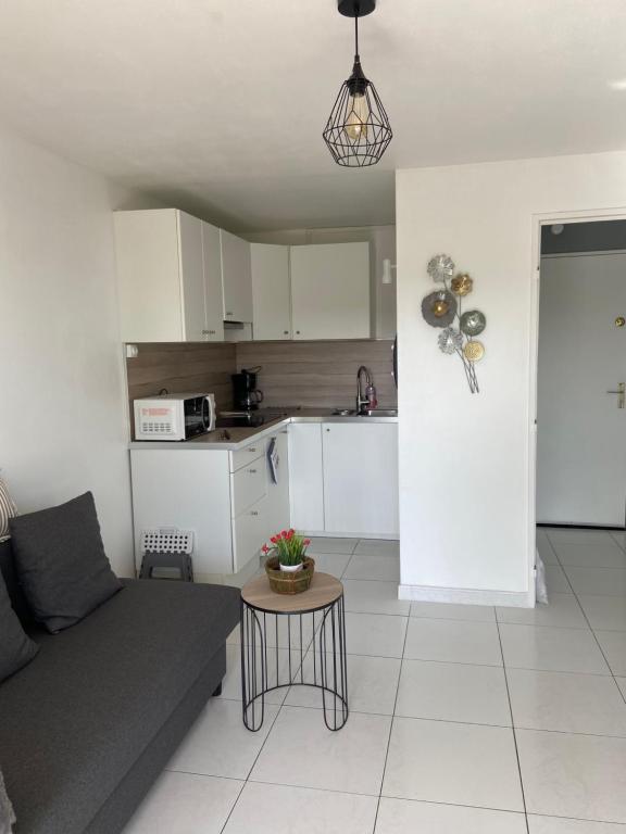 un salon avec un canapé et une table dans l'établissement Vue mer et verdure, à Villers-sur-Mer