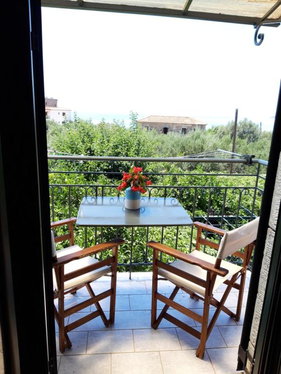 een tafel en 2 stoelen op een balkon bij Skardamoula's Studios and Apartments, 2 in Kardhamili