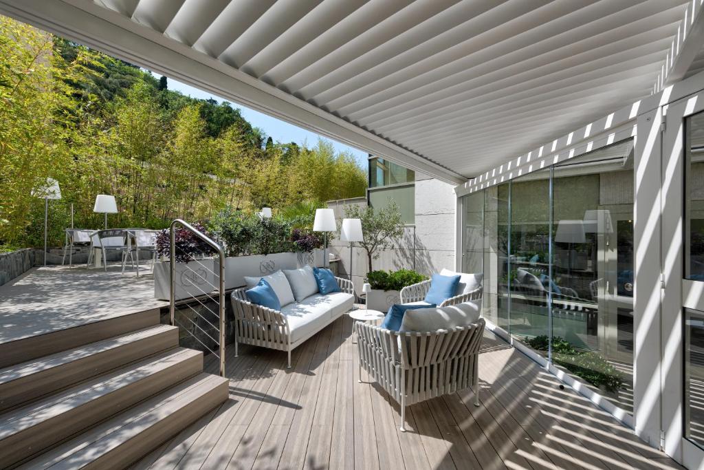 a patio with a couch and chairs on a deck at Carrick Hotel Camogli Portofino Coast in Camogli