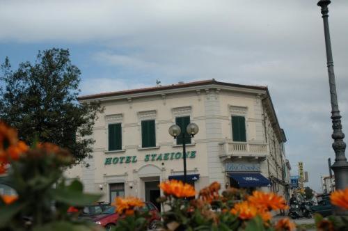 ein weißes Gebäude mit grünen Fenstern und einem Straßenlicht in der Unterkunft Hotel Stazione in Livorno