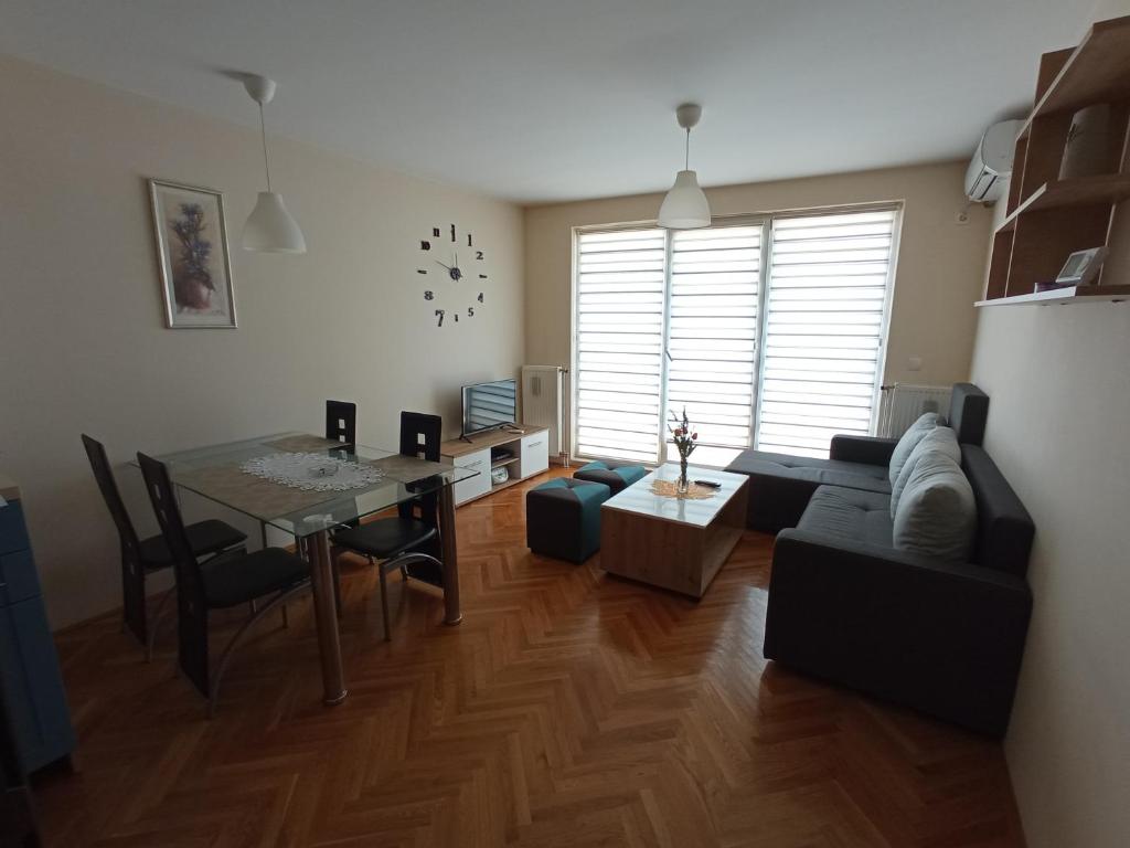 een woonkamer met een bank en een tafel bij Apartman STANKOVIĆ in Veliko Gradište