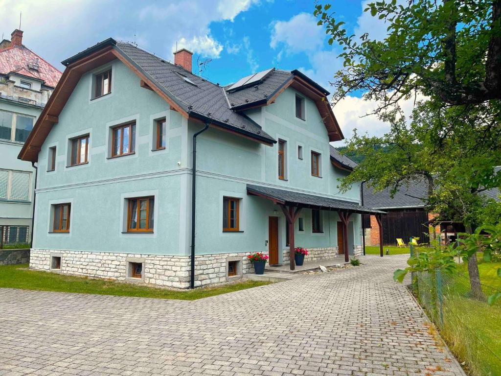 une grande maison blanche avec un toit noir dans l'établissement Apartmánový dům Michael, à Lipová-lázně