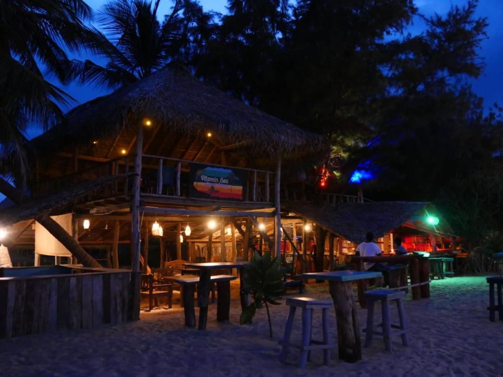 a restaurant with tables and chairs at night at Vitamin Sea Beach Cabana in Nilaveli
