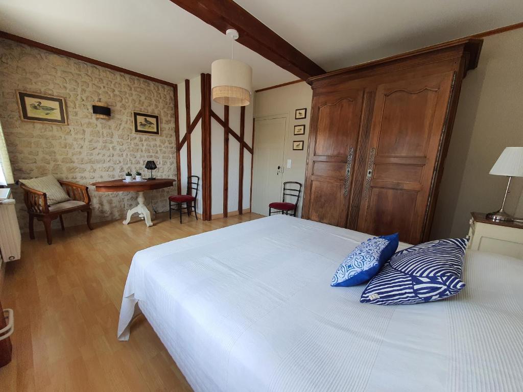 1 dormitorio con 1 cama blanca grande con almohadas azules en Le Pressoir de Marsac en Marsac