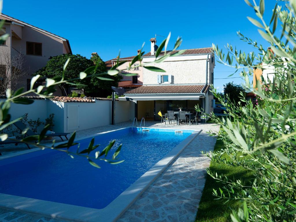 una piscina frente a una casa en Casa Lampadina with Private Pool, en Vižinada