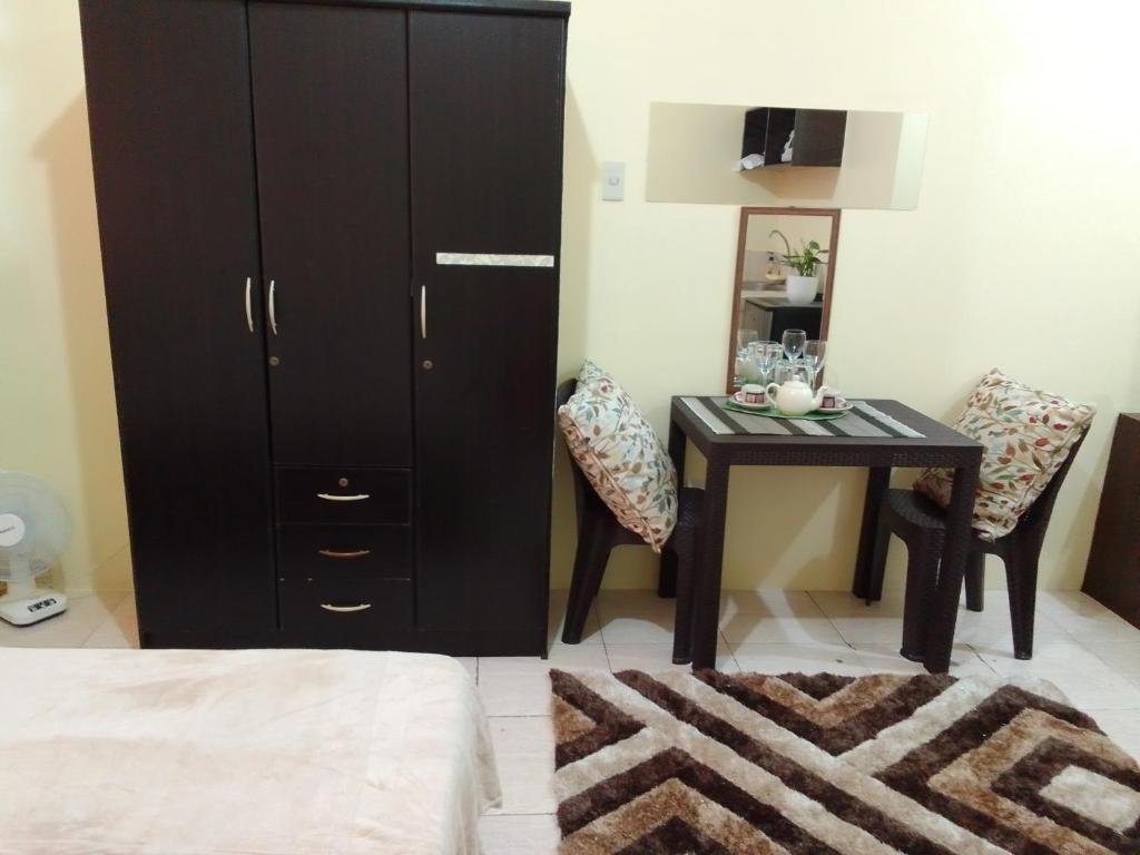 1 dormitorio con armario negro y mesa en Guest House in Cainta Rizal, en Cainta