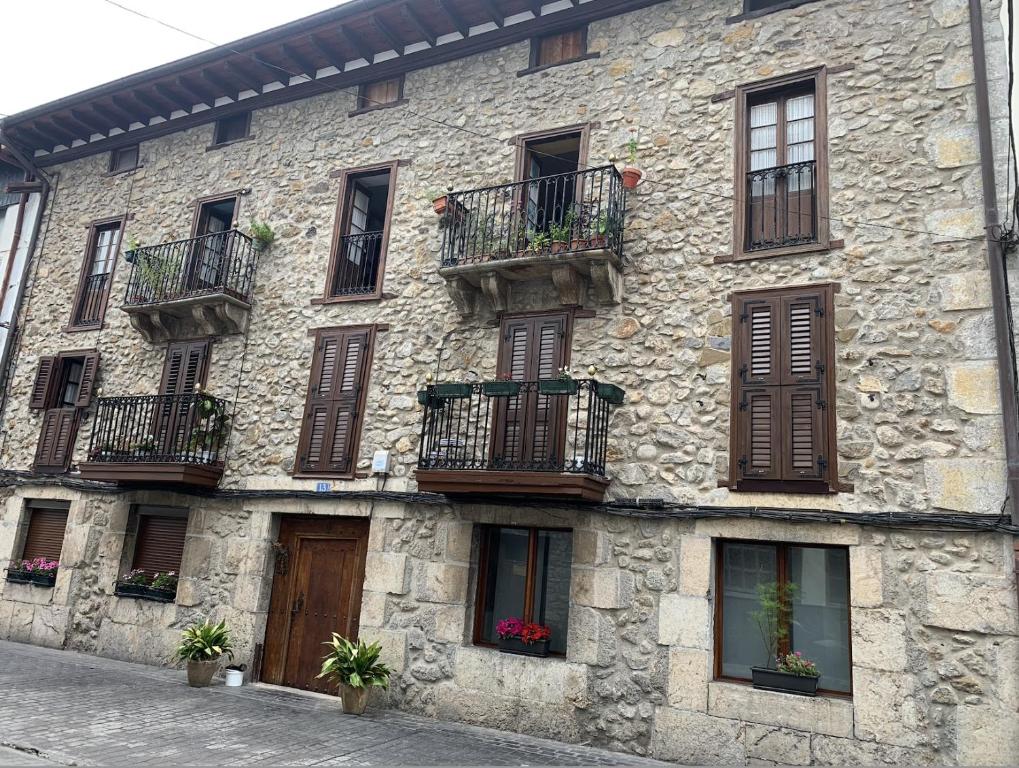 a stone building with windows and balconies on it at Salabardoa Ea in Ea