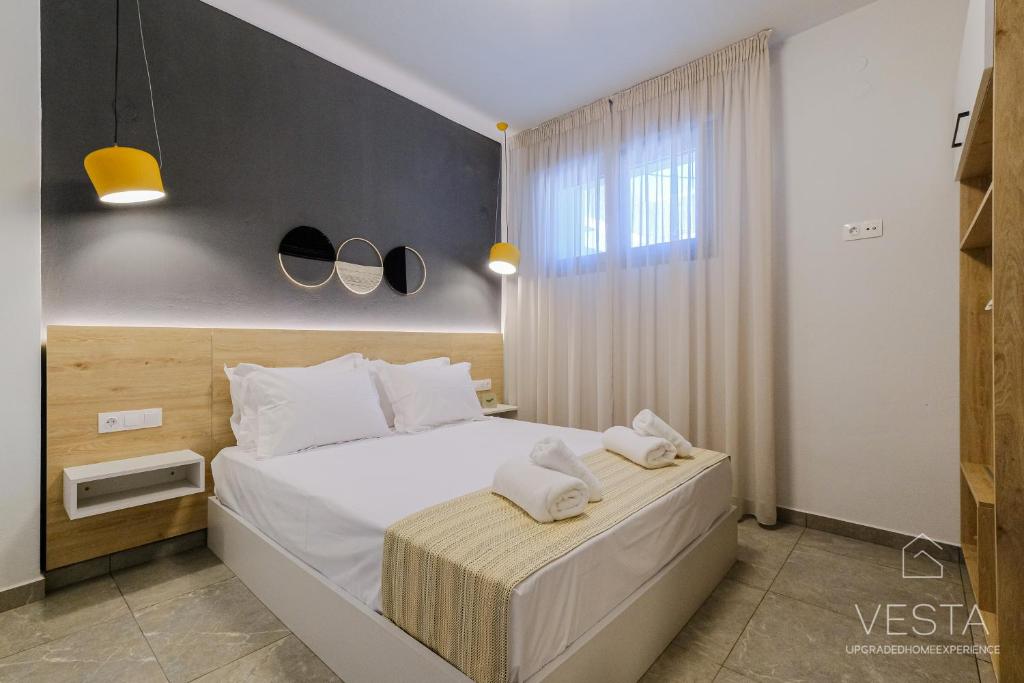 a bedroom with a bed with two towels on it at De Mar Village Apartments, Agios Nikolaos in Agios Nikolaos