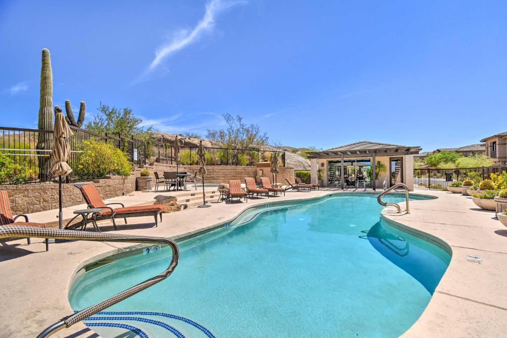 a large swimming pool with chairs at Sunny Scottsdale Condo with Resort-Style Perks! in Scottsdale