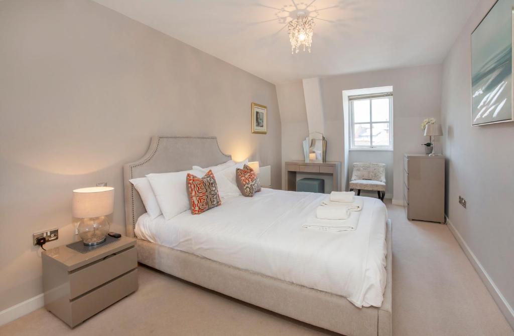 - une chambre avec un grand lit blanc et une fenêtre dans l'établissement Loft Apartment Central York with Parking, à York