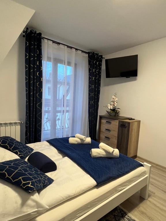 um quarto com uma cama grande e uma televisão em Apartamenty Cichy Kącik em Poronin