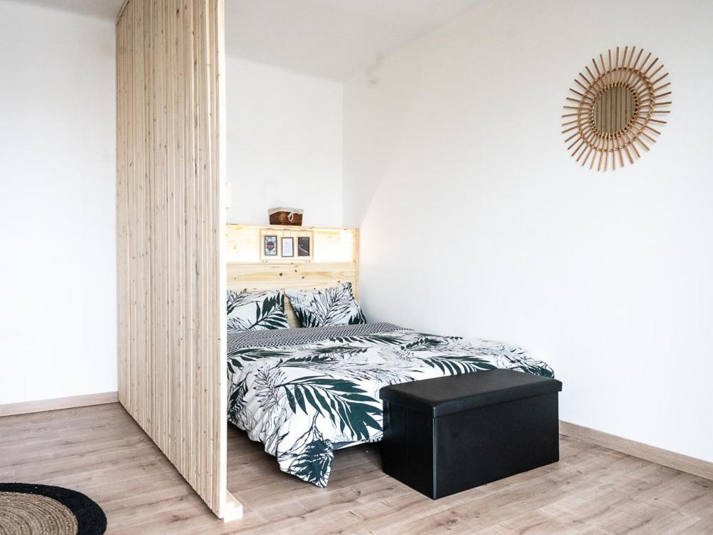 - une petite chambre avec un lit et un pouf noir dans l'établissement Studio cocooning 2 étoiles I wifi I clim I plage 7min à pied, à Fréjus