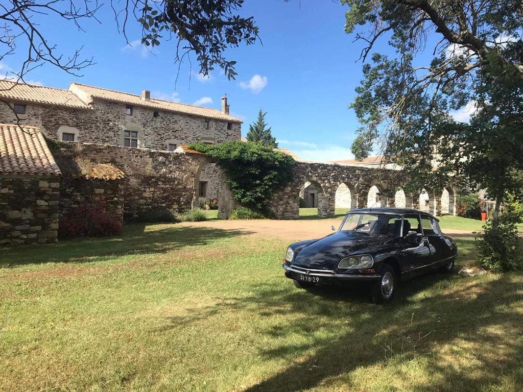 a black car parked in the grass in front of a building at Abbaye de Capservy in Villardonnel