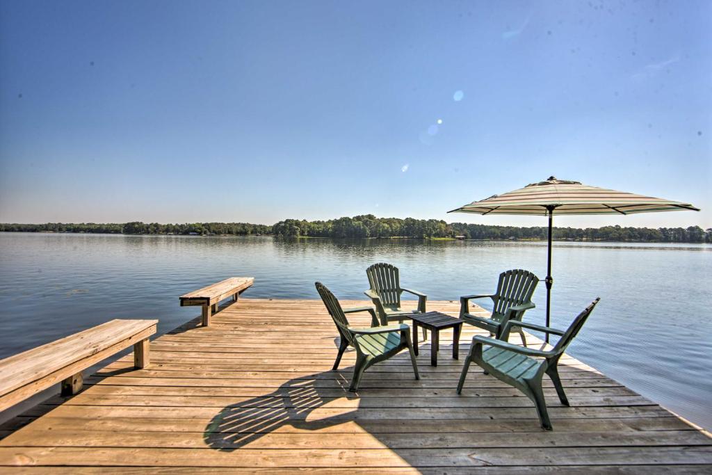 una mesa y sillas en un muelle con sombrilla en Quiet Home on Lake Hawkins with Kayaks and Dock!, en Hawkins