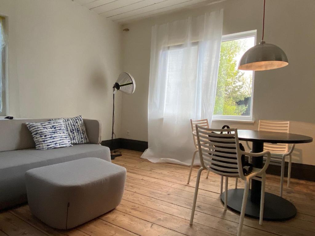 サラツグリーヴァにあるHoliday apartment near the seaのリビングルーム(ソファ、テーブル、椅子付)