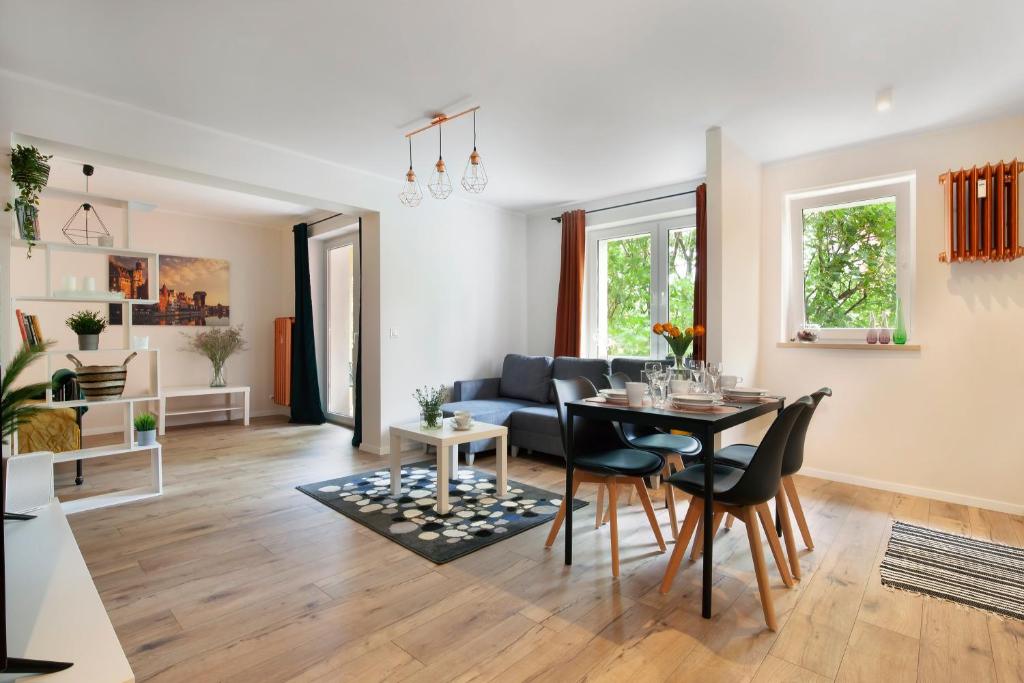 uma sala de estar com uma mesa e um sofá em Elite Apartments Center Deluxe em Gdansk