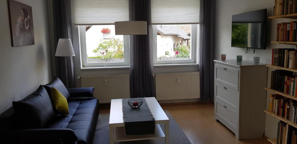 a living room with a blue couch and two windows at Ferienwohnung klein Treben 3.0 in Fockendorf