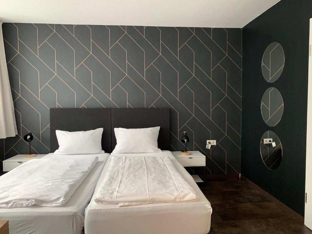 a bedroom with two beds and two night stands at MOTELO Bielefeld - Smart HOTEL in Bielefeld