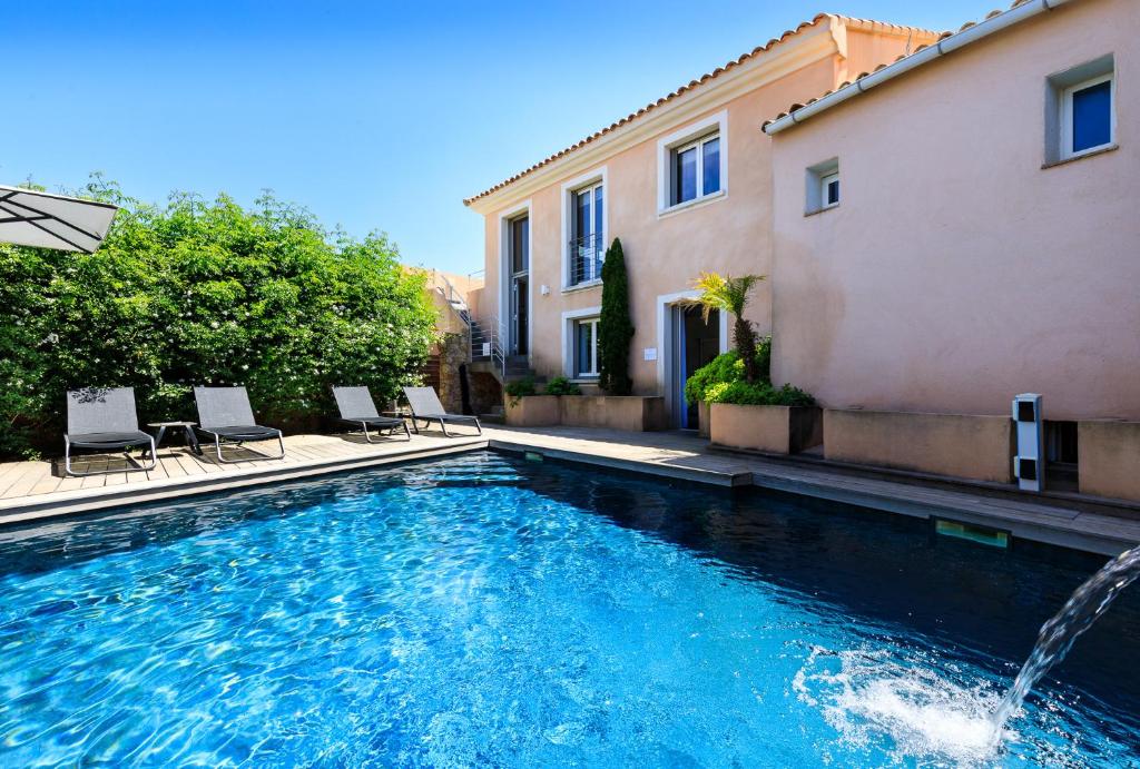 - une piscine avec des chaises à côté d'un bâtiment dans l'établissement U CASALE, à Santa-Reparata-di-Balagna