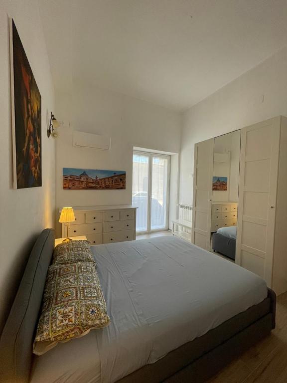 Un dormitorio con una cama grande y una ventana. en Casa in piazzetta, en Balestrate