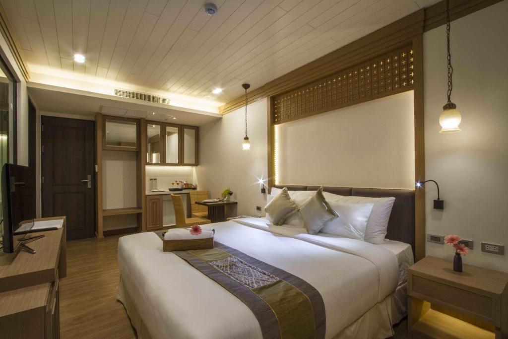 A king-style bedroom combines warm wood detailing with a bright upholstered bed.