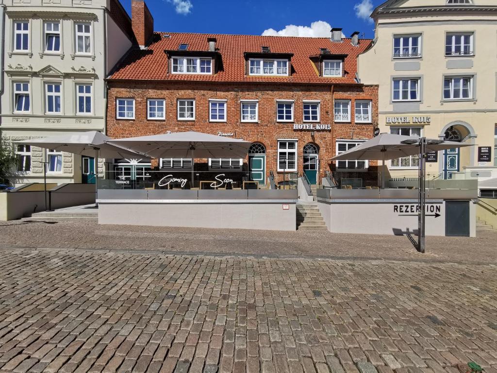 a building with a cafe in the middle of a street at Hotel KO15 in Lübeck