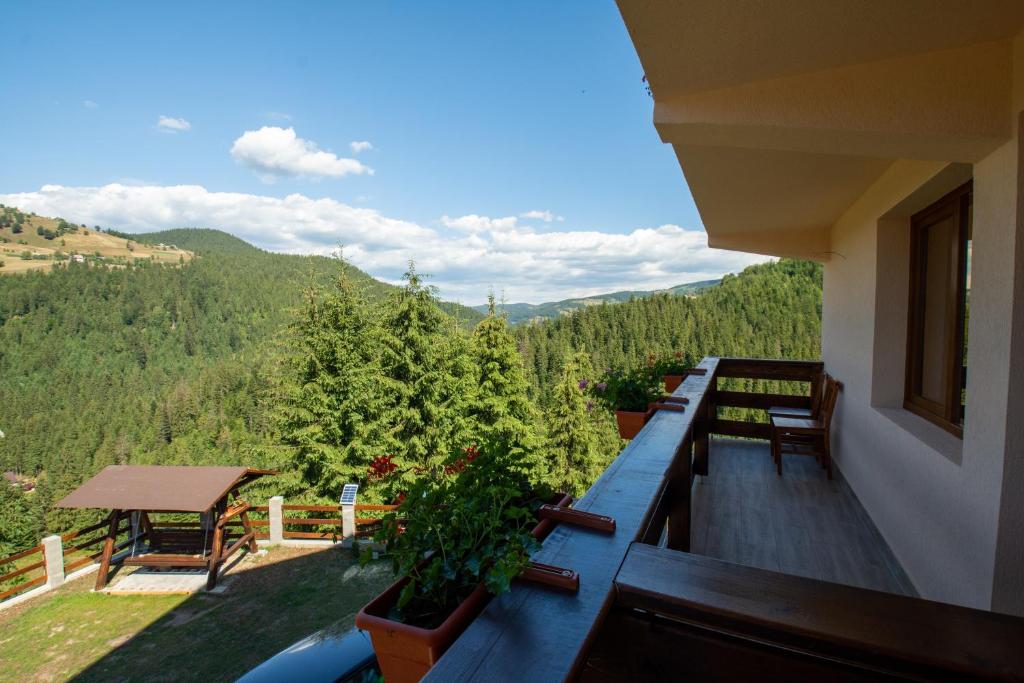 a balcony with benches and a view of the mountains at Denisa's Lodge in Arieşeni