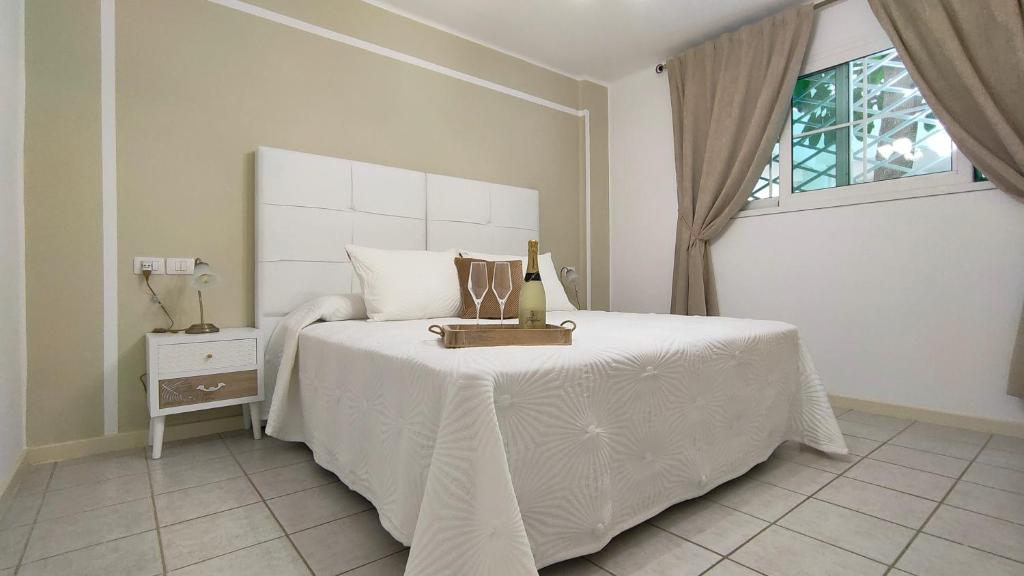 Schlafzimmer mit einem großen weißen Bett und einem Fenster in der Unterkunft Rocas del Mar 129 in Costa Del Silencio