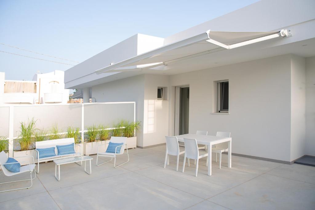 eine Terrasse mit einem weißen Tisch und Stühlen in der Unterkunft Residence BLANCO GARDEN 1 a 100 mt dalla spiaggia di Posto Vecchio Marina di Pescoluse in Marina di Pescoluse