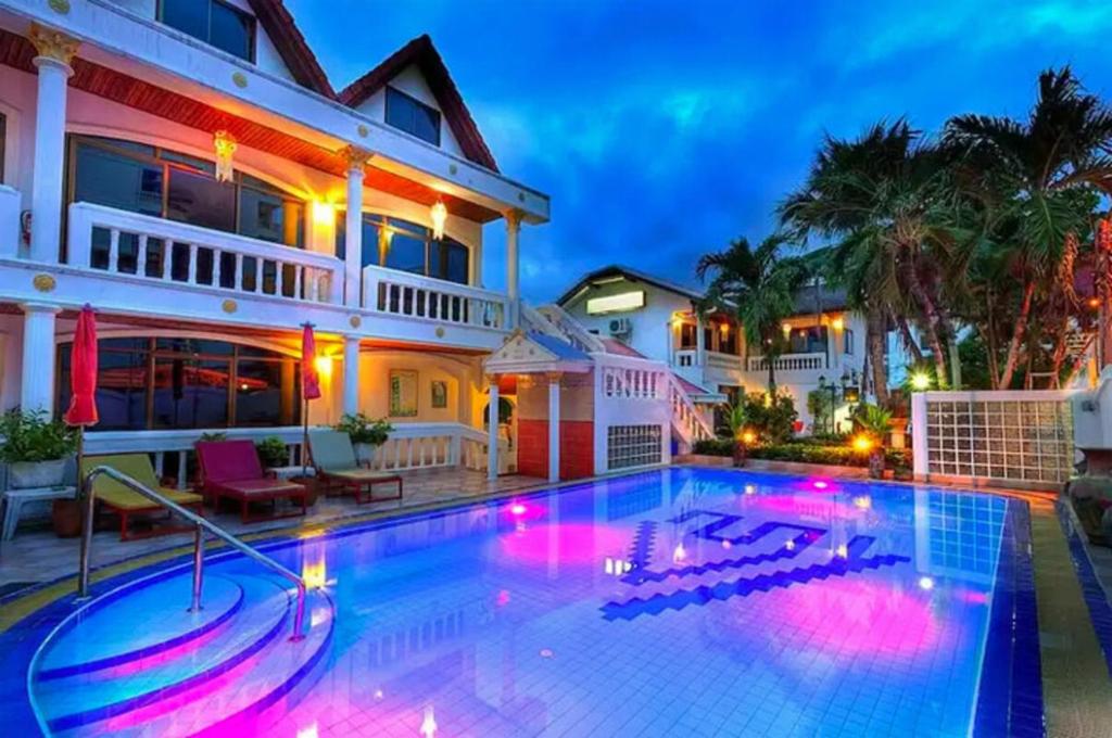 a large swimming pool in front of a house at Villa Oranje Pattaya in Pattaya Central