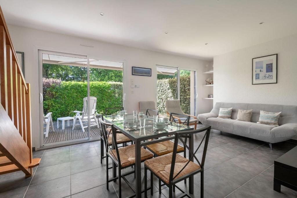 a living room with a glass table and chairs at À 200m du Port de Crouesty, Maison 6 personnes in Arzon