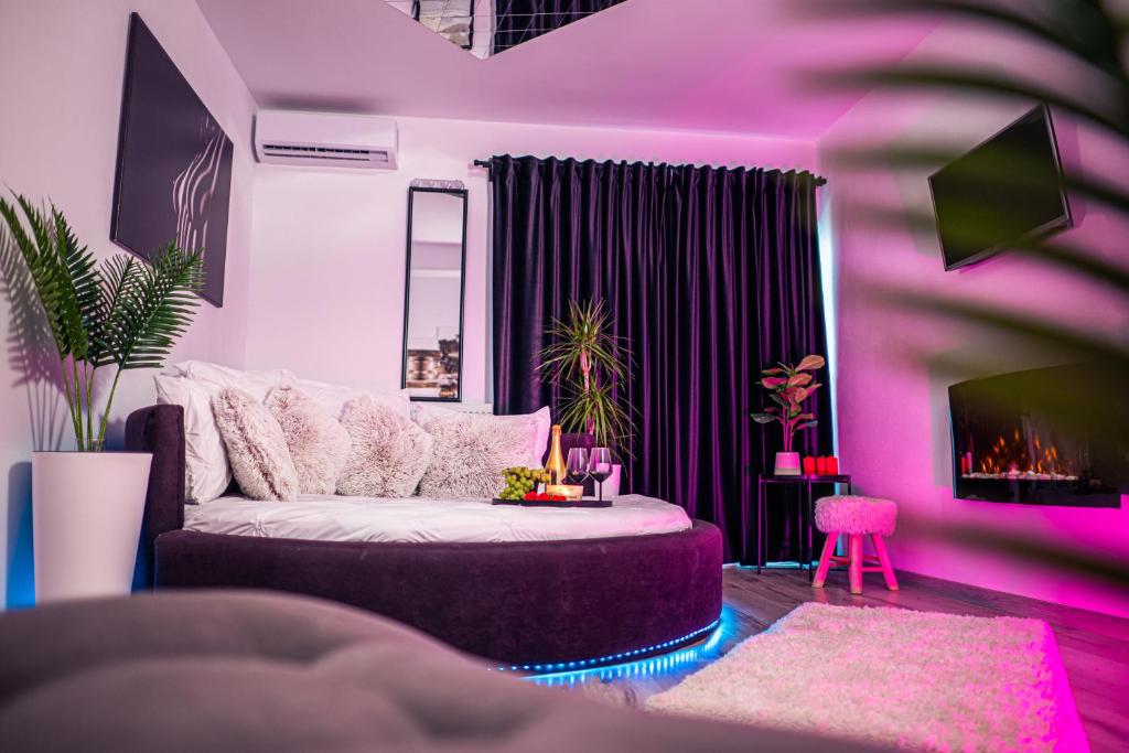 Sala de estar de color púrpura con sofá y TV en Apartament Craiova Modern Space Semineu Pat Rotund, en Craiova