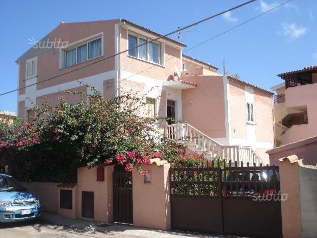 une maison avec une clôture et une voiture garée devant elle dans l'établissement La casa di Sara, à Santa Teresa Gallura